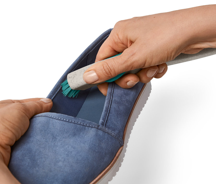 Hände reinigen einen blauen Schuh mit einer 2-in-1-Grobschmutz-Schuhreinigungsbürste.