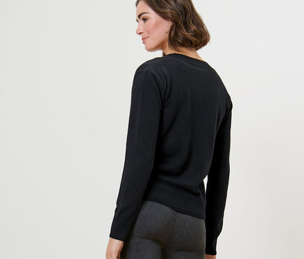 Frau posiert in Feinstrick-Cardigan mit Cashmere und grauer Hose.