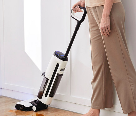 Frau benutzt Tineco Floor One S7 Steam Plus Dampfreiniger auf Holzboden.