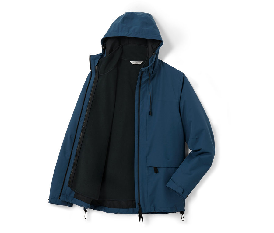 Eine blaue Outdoorjacke mit Weste ist offen und die schwarze Weste ist sichtbar.