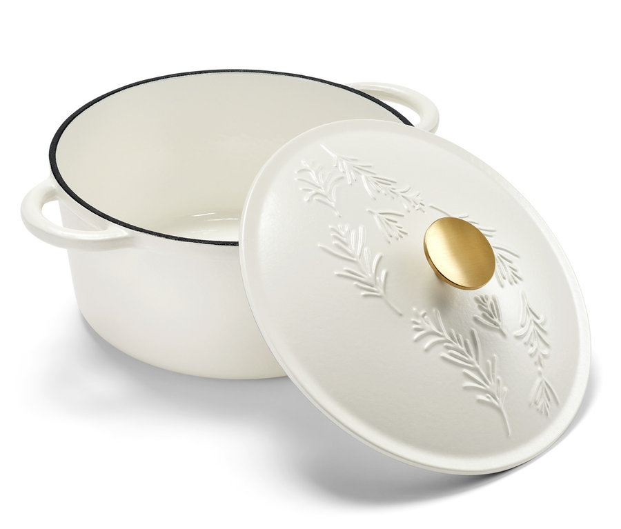 Weißer Gusseisen-Topf mit Deckel, der mit einem Pflanzenmotiv verziert ist.