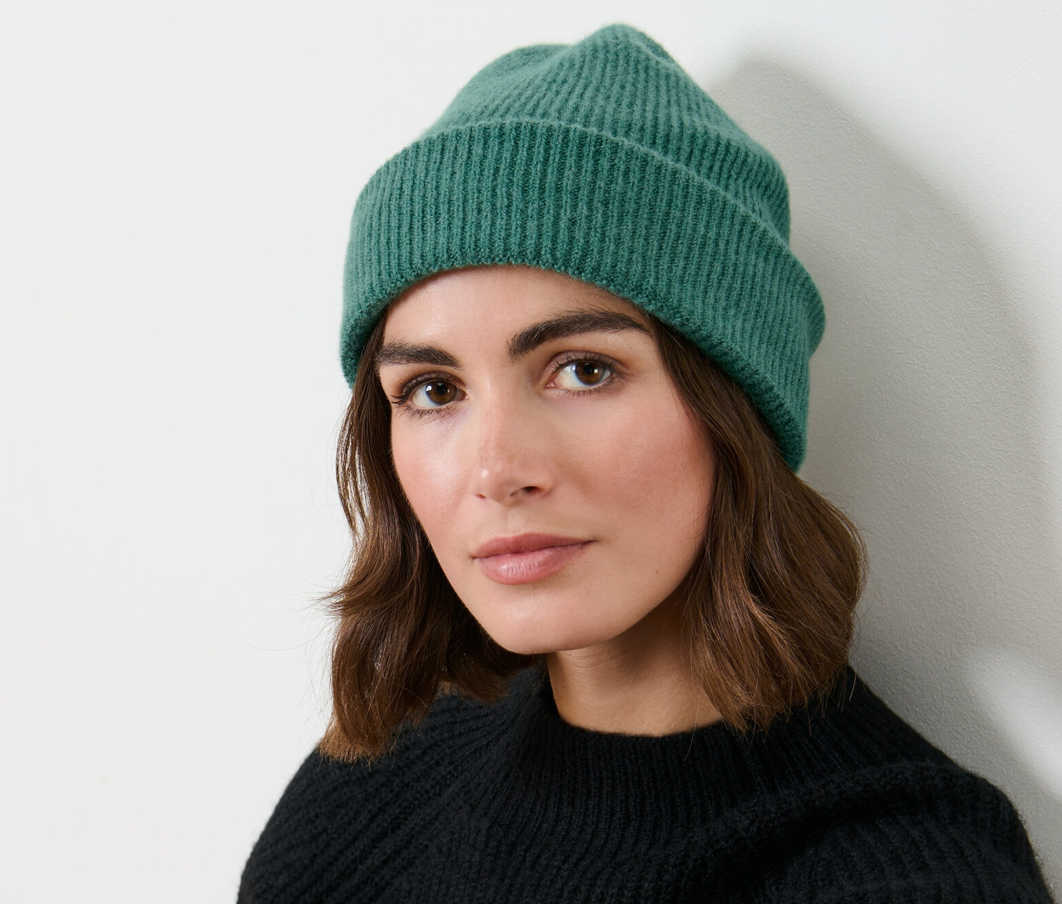 Frau trägt eine grüne Strickmütze.