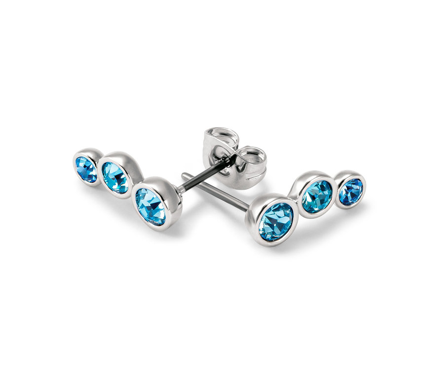 Zwei silberne Ohrstecker Blue Shades mit blauen Steinen liegen auf einem weißen Hintergrund.