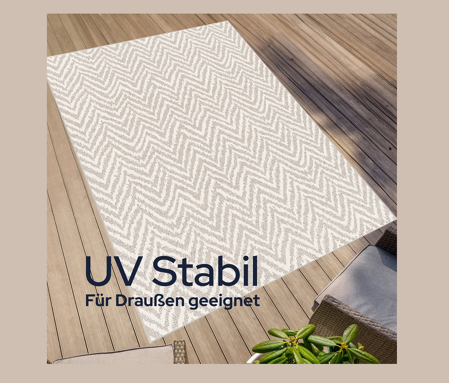 Draufsicht eines beigen Outdoor-Teppichs »Ecru Flow« mit Zickzackmuster auf einer Holzterrasse.