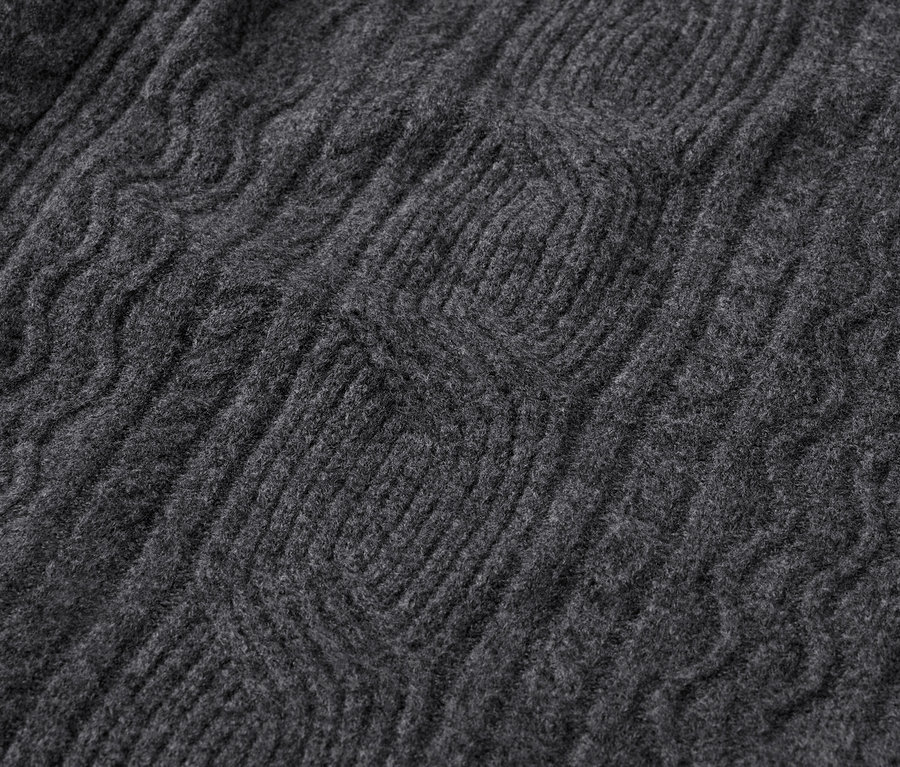Detailaufnahme eines grauen Strickpullovers mit Zopfmuster.