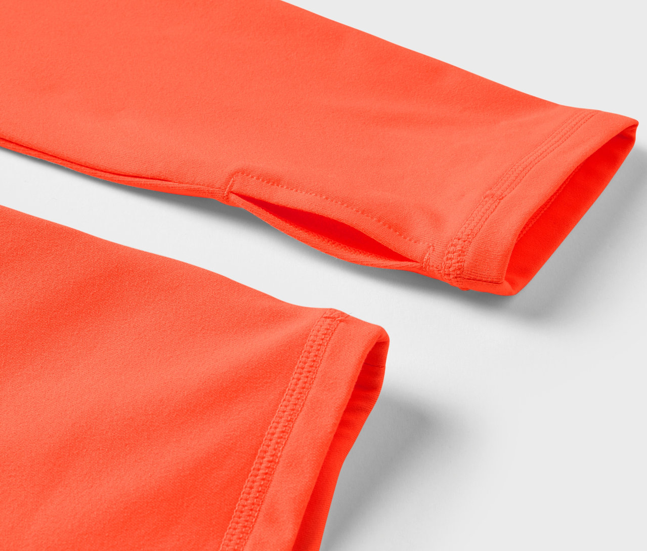 Detailaufnahme eines orangefarbenen Langarmshirts mit Daumenloch.