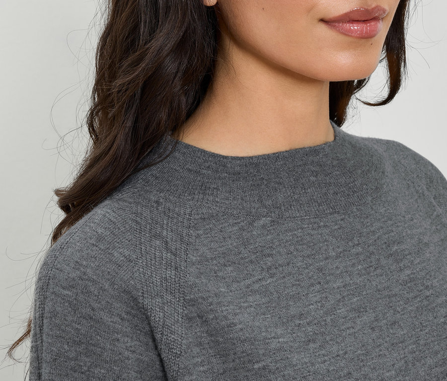 Detailaufnahme eines grauen Damenpullovers mit langen Ärmeln und Rundhalsausschnitt.