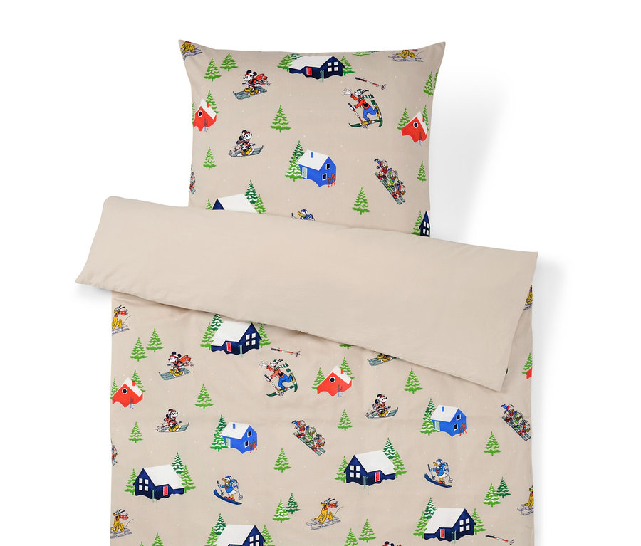 Bettwäsche mit Winterlandschaftsmuster mit Häusern, Bäumen und Skifahrern.