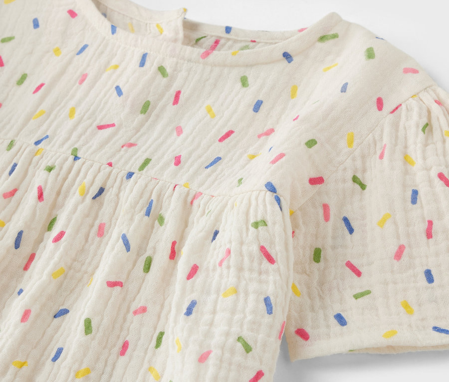 Detail einer Kinder-Musselin-Bluse mit bunten Streuseln.