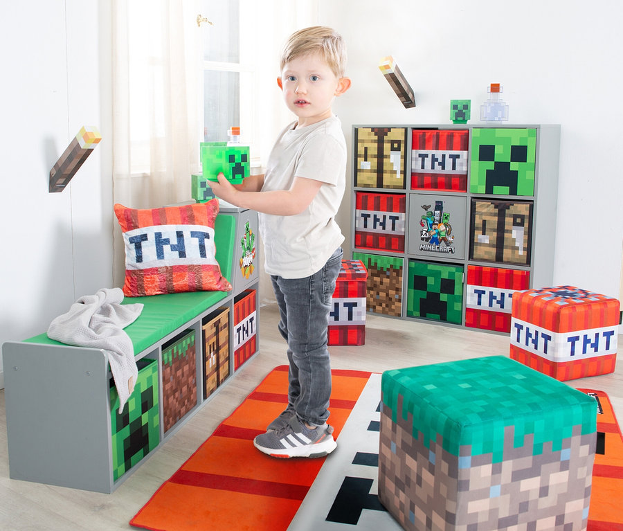 Ein Junge hält einen Minecraft-Würfel in einem Kinderzimmer. Im Zimmer stehen Minecraft-Möbel. 2 roba Minecraft Sitzhocker sind auch vorhanden.