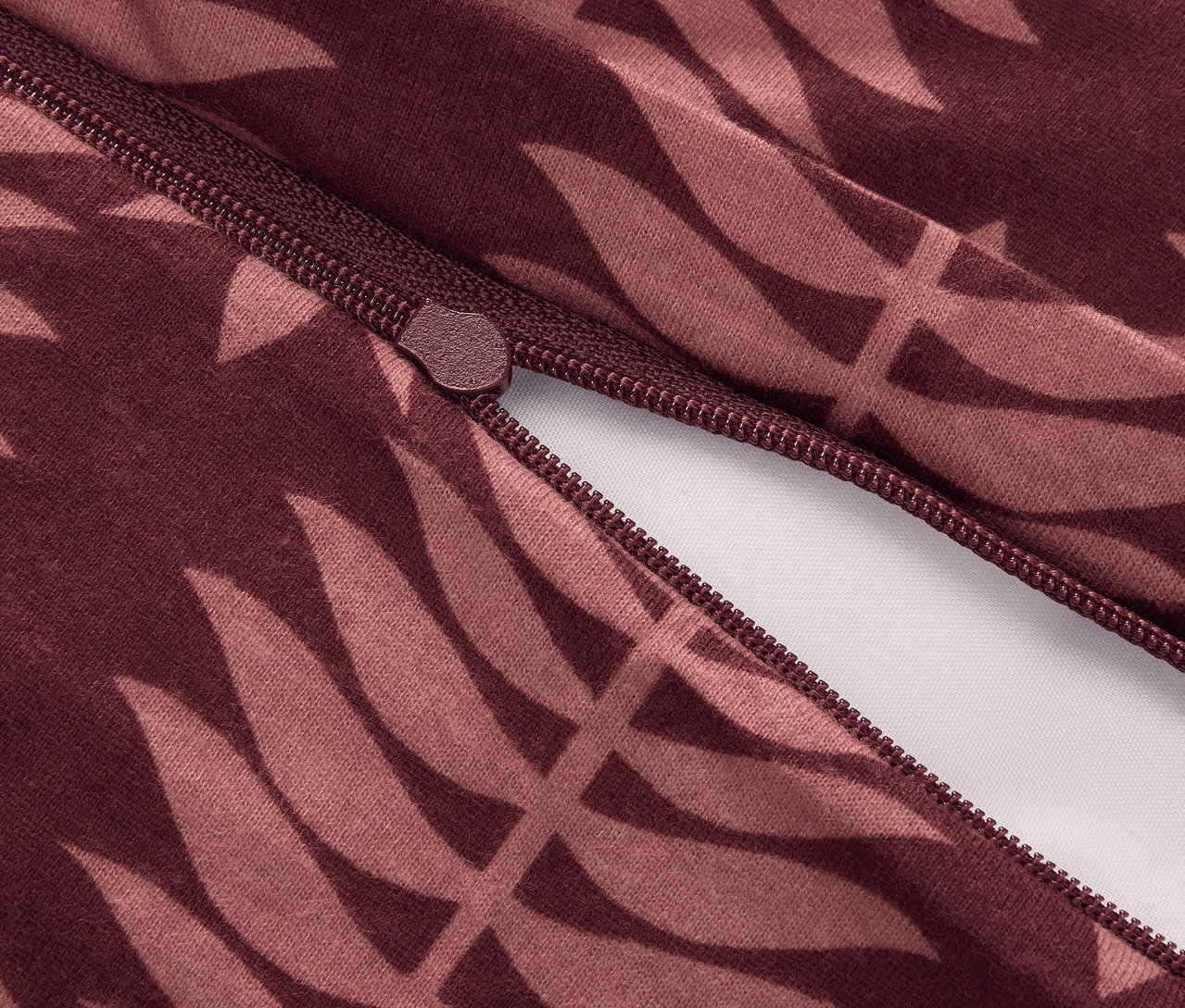 Nahaufnahme von einem Reißverschluss an normalgroßer Winterjersey-Bettwäsche mit Blattmuster.