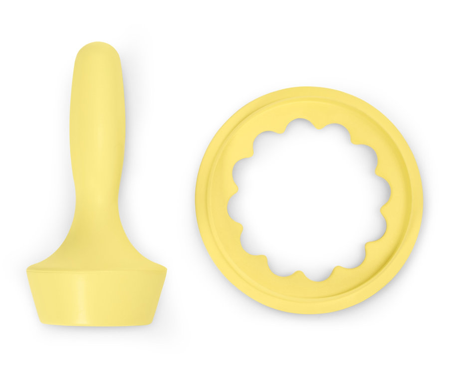 Ein gelber Teigstampfer und ein Ausstecher für Kekse auf einem weißen Hintergrund.