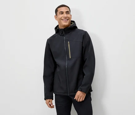 Mann lächelt und trägt eine schwarze Jacke mit Kapuze.