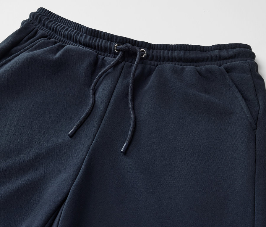 Detailaufnahme einer dunkelblauen Sweathose mit Kordelzug.