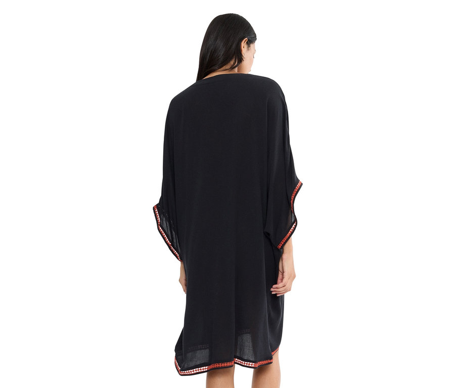 Frau von hinten in schwarzem Kaftan mit roter Bordüre.