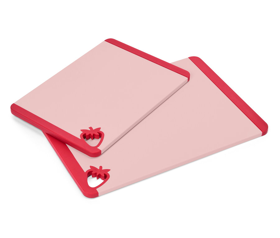 Zwei rechteckige, rosa Schneidebretter mit roten Erdbeer-Akzenten an einer Ecke liegen übereinander.