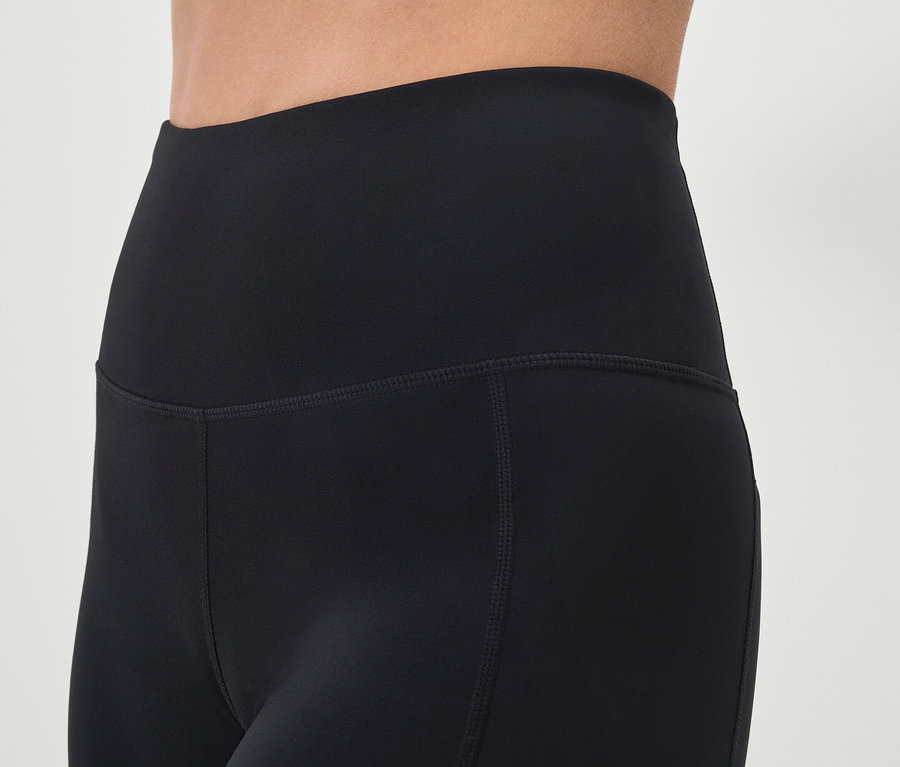 Nahaufnahme von schwarzen Leggings an einer Person.