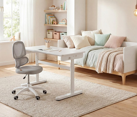 In einem Kinderzimmer stehen ein grauer Bürostuhl und ein weißer Schreibtisch auf einem Teppich vor einem weißen Tagesbett.