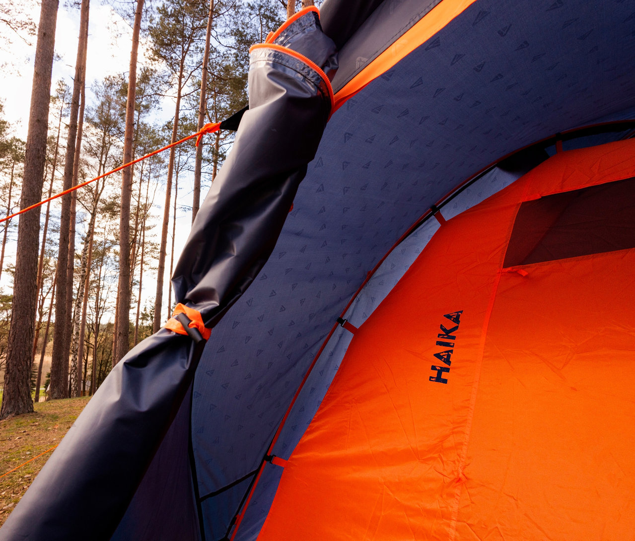 Innenansicht eines orangefarbenen Tambu »HAIKA 3« 3 Personen Kuppelzelts im Wald.