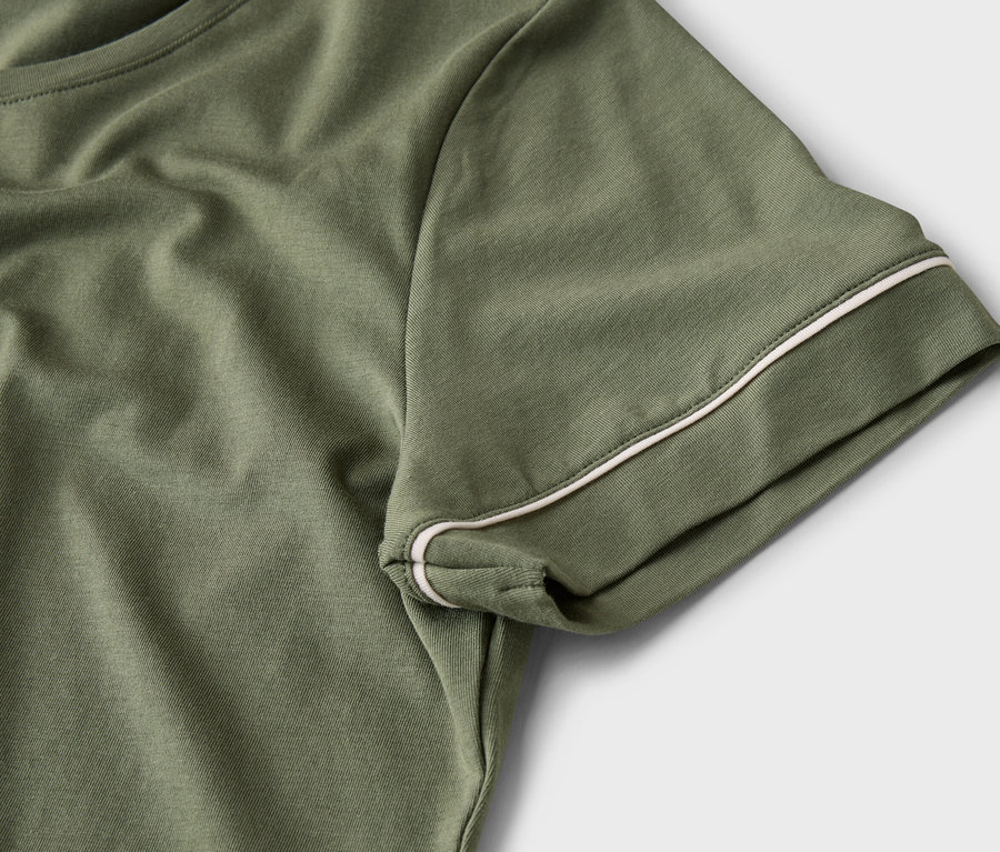 Nahaufnahme eines olivgrünen T-Shirts mit weißen Paspeln am Ärmel