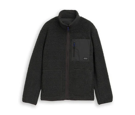 Dunkelgraue Tom Tailor Teddyjacke mit Stehkragen, durchgehendem Reißverschluss, zwei Seitentaschen und einer Brusttasche mit blauem Reißverschluss.