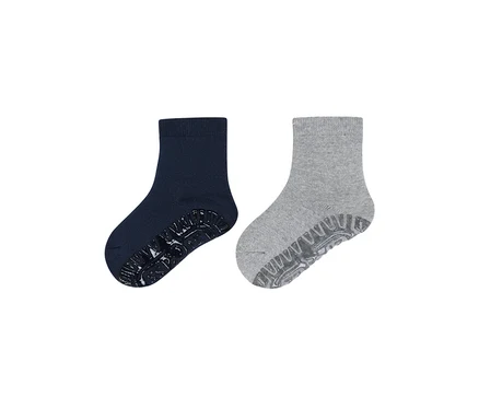 Zwei knöchelhohe Socken, eine dunkelblaue und eine hellgraue, beide mit Antirutsch-Sohlen.