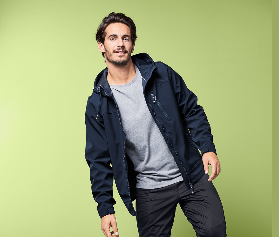 Mann posiert in Softshelljacke.