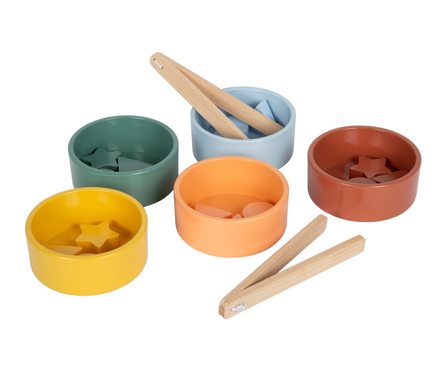 Fünf bunte Schalen mit passenden Holzformen und zwei Holzzangen. Eine gelbe Schale mit Sternen, eine grüne mit Dreiecken, eine hellblaue mit Kreisen und einer Zange, eine orangefarbene mit Halbkreisen und eine terrakottafarbene mit Sternen. Eine weitere Zange liegt daneben.