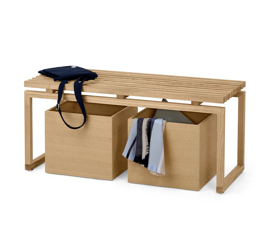 Holzbank mit zwei Aufbewahrungsboxen, auf der Bank liegt eine blaue Tasche.