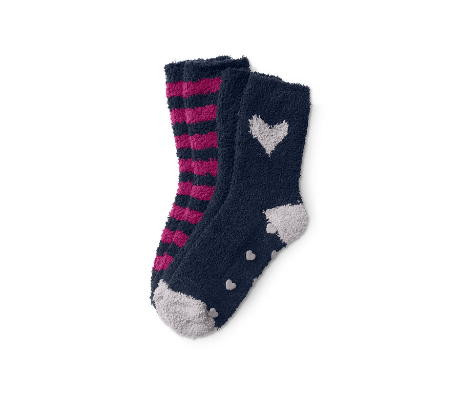 Zwei Paar flauschige Kuschelsocken: ein Paar gestreift in Pink und Schwarz, das andere marineblau mit weißen Herzen.