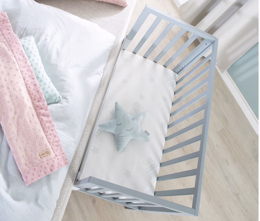 Draufsicht auf roba 2-in-1-Beistellbett »safe asleep®«, taupefarben, mit Stern, und Bett mit rosa Kissen.