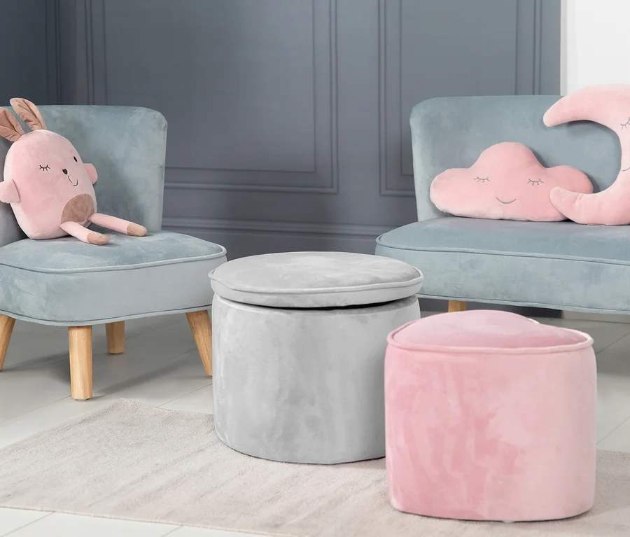 Zwei blaue Kindersessel mit rosa Plüschtieren, ein grauer und ein rosa Hocker auf einem beigen Teppich. Auf einem Sessel sitzt ein grauer roba Kinderhocker mit Aufbewahrungsfunktion »Lil Sofa«.