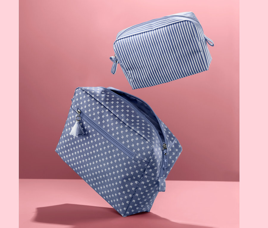 Zwei Kulturtaschen-Sets: Eine blau mit weißen Punkten und eine mit blau-weißen Streifen.