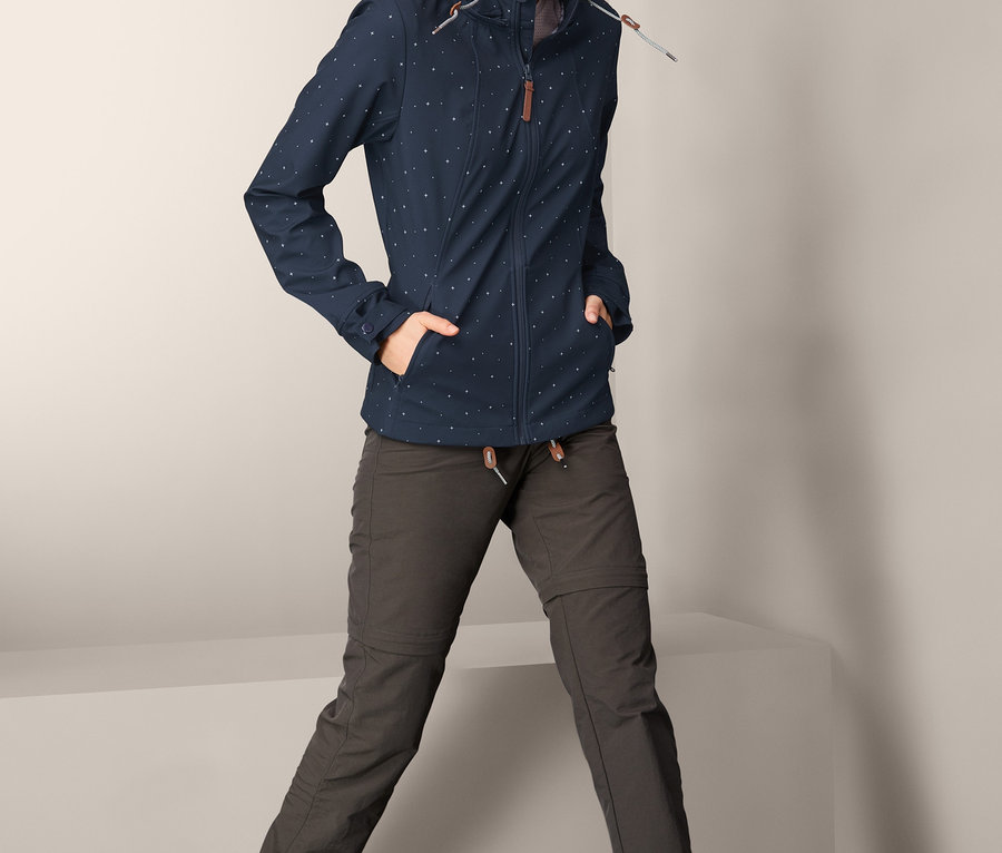 Frau posiert in gemusterter Softshell-Jacke.
