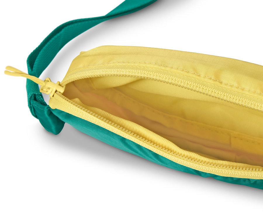 Geöffnete Hüfttasche mit gelbem Innenraum und grün-gelbem Äußeren.