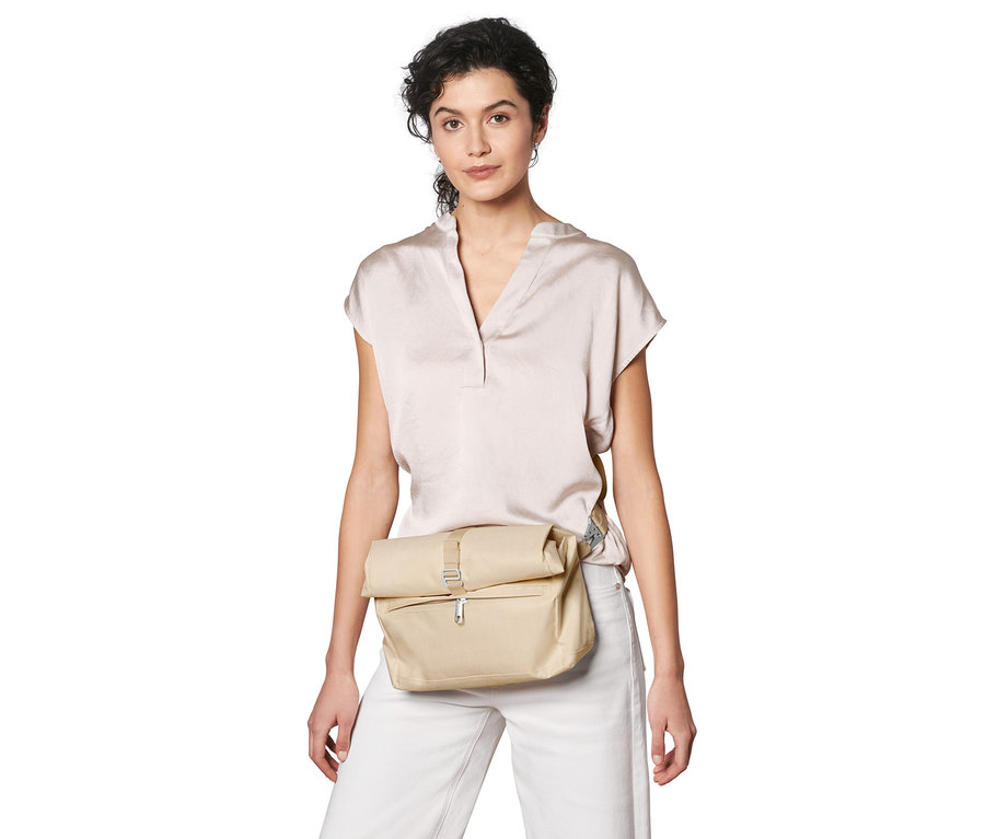 Frau trägt eine beige Sicherheits-Umhängetasche.