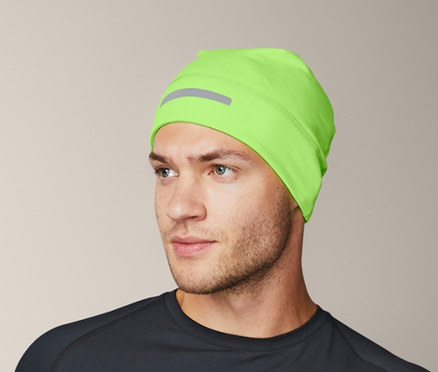 Mann in schwarzem Thermoset und neon-grüner Thermomütze.
