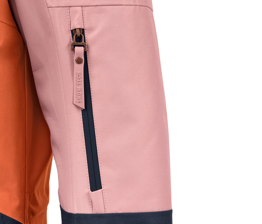 Detail einer farblich abgesetzten Ski- und Snowboardjacke mit Reißverschlusstasche.