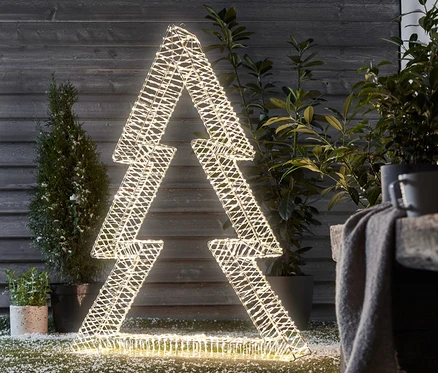 Eine mittelgroße, beleuchtete 3D-LED-Tanne steht draußen auf dem Rasen.