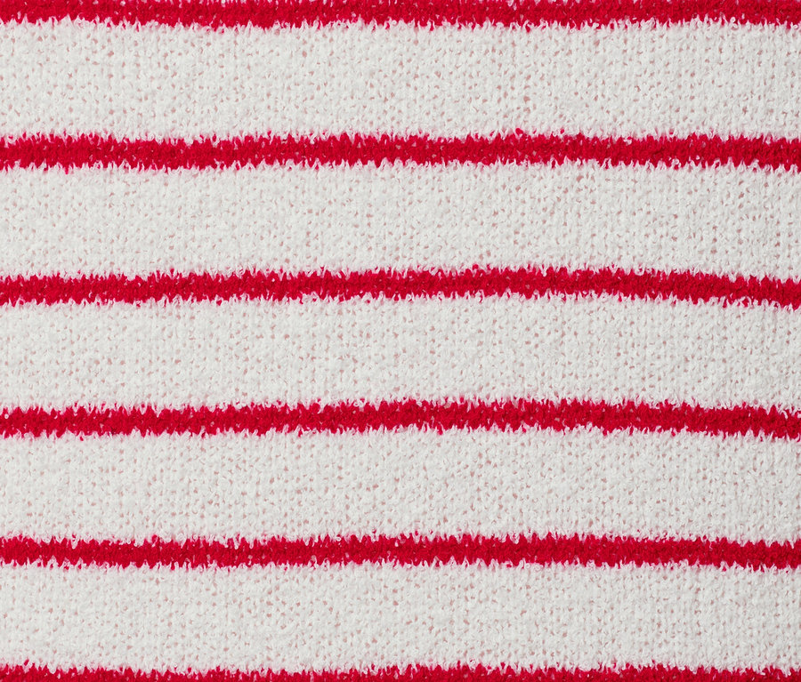 Detailansicht einer Strickjacke in Boucléoptik mit roten Streifen.
