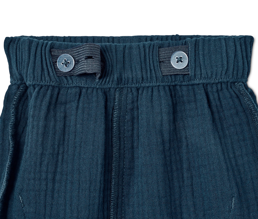 Nahaufnahme der marineblauen Schlupfhose aus Bio-Baumwolle mit Knöpfen.