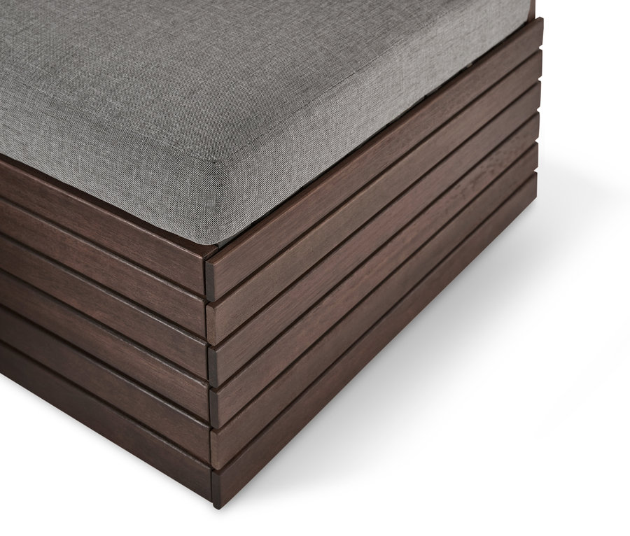 Detailansicht eines Fußteil-Moduls mit Relax-Komfort-Kissen. Braune Holzkonstruktion mit grauem Kissen.