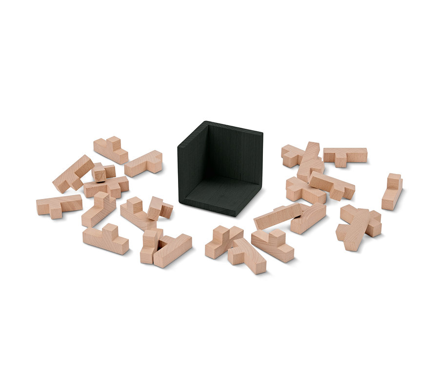 Ein zerlegter IQ-Puzzlewürfel mit Holzteilen und einem schwarzen Eckteil.