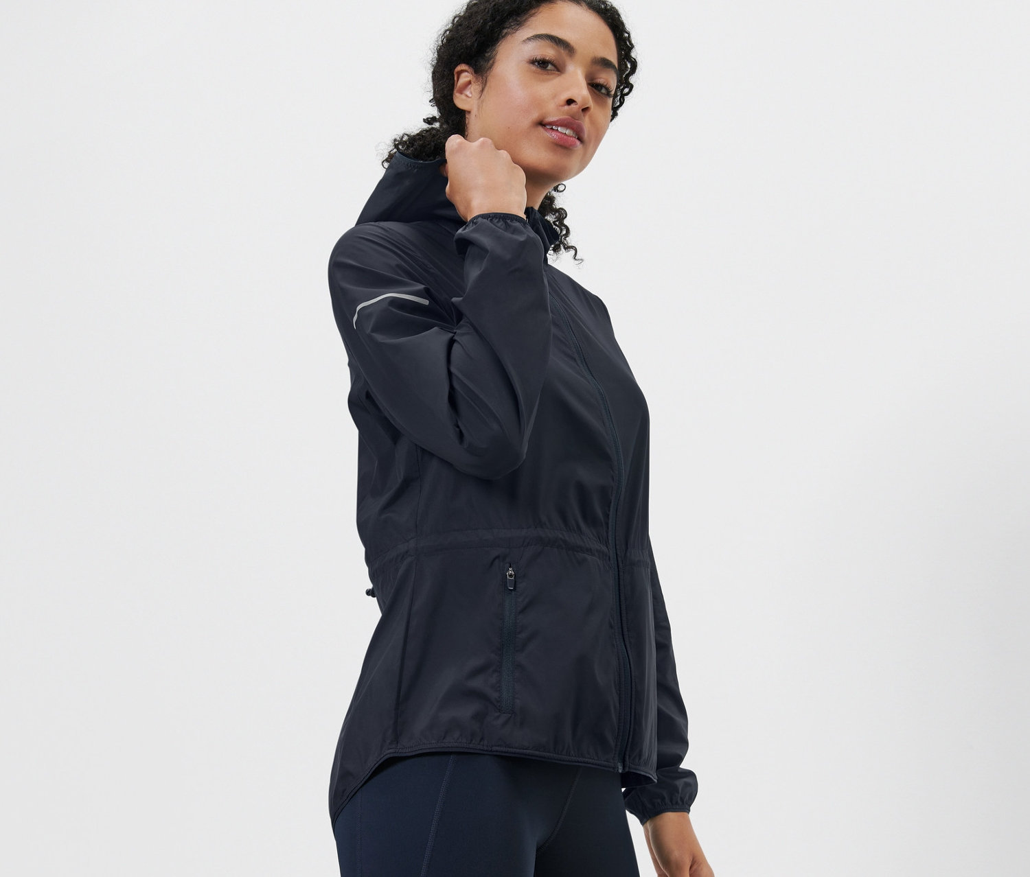 Frau posiert in Lightweight-Laufjacke.