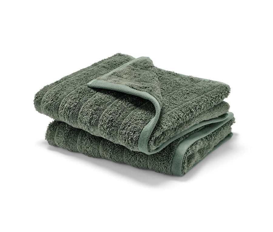 Zwei grüne Premium-Handtücher gestapelt.