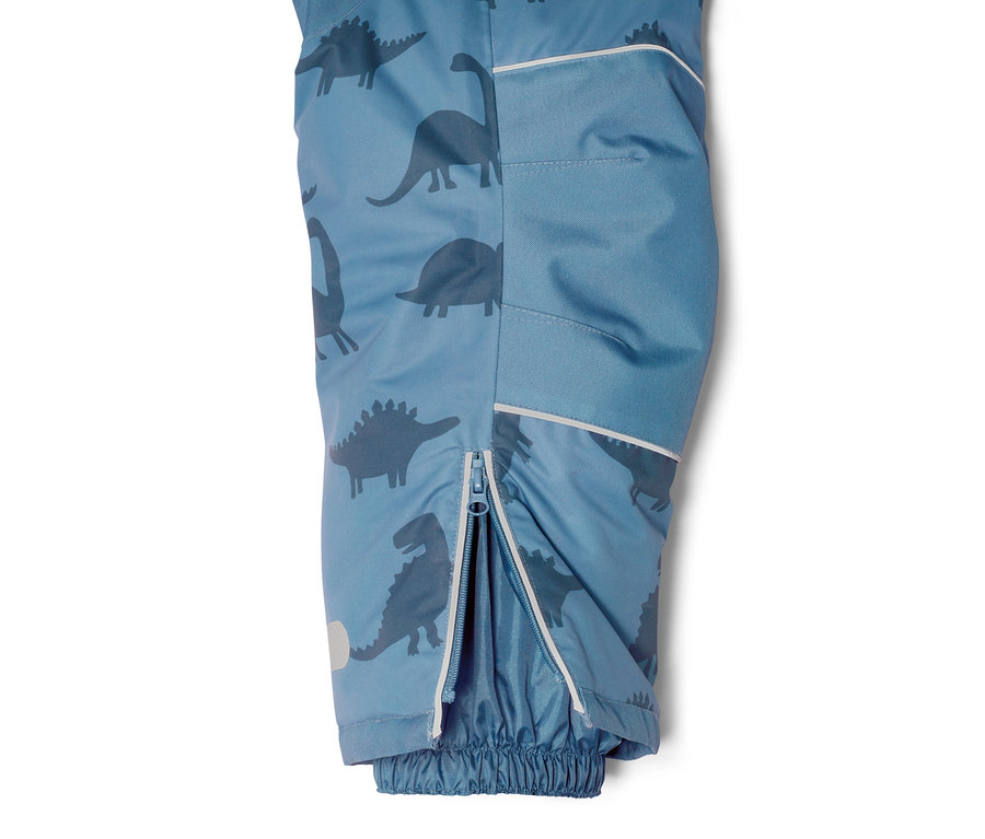 Detailansicht eines Kinder-Schneeanzugs mit Dino-Print und geöffnetem Reißverschluss am Bein.