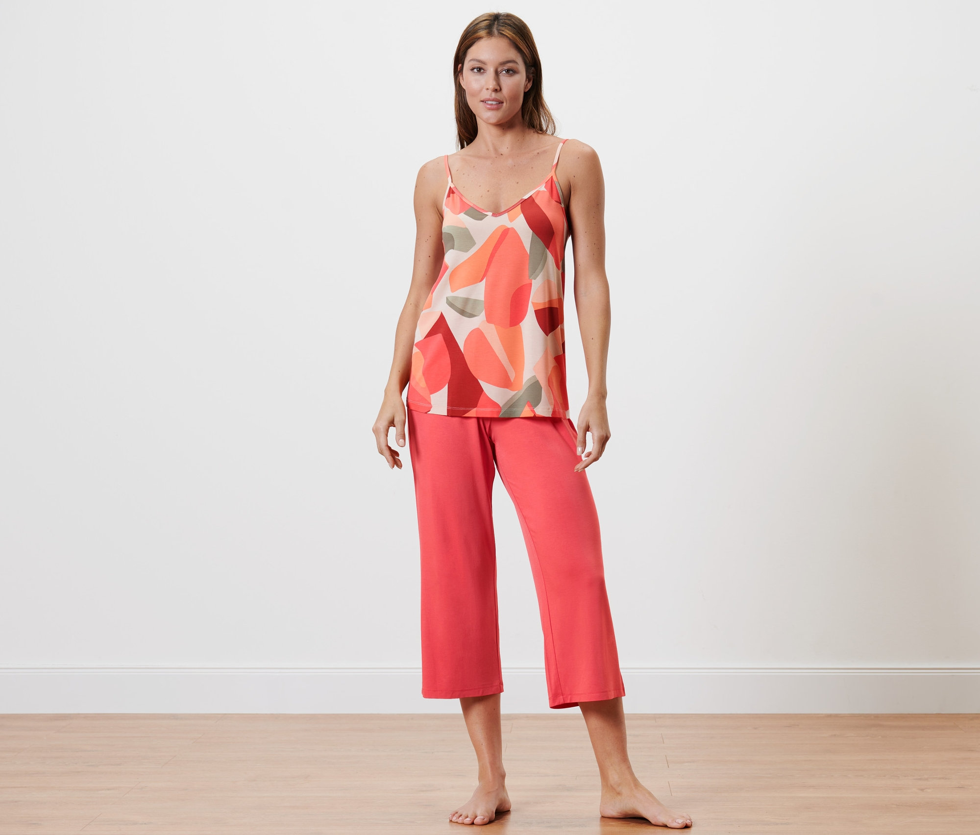 Frau steht und trägt einen Pyjama in 7/8-Länge.