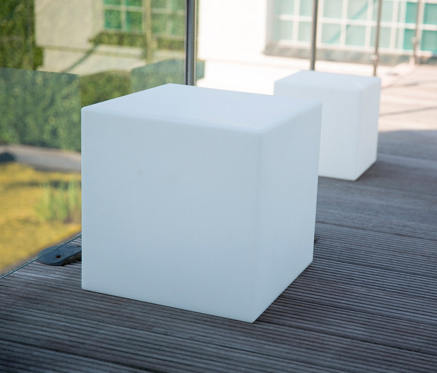 Zwei weiße Solar-Würfel auf einem Holzboden.