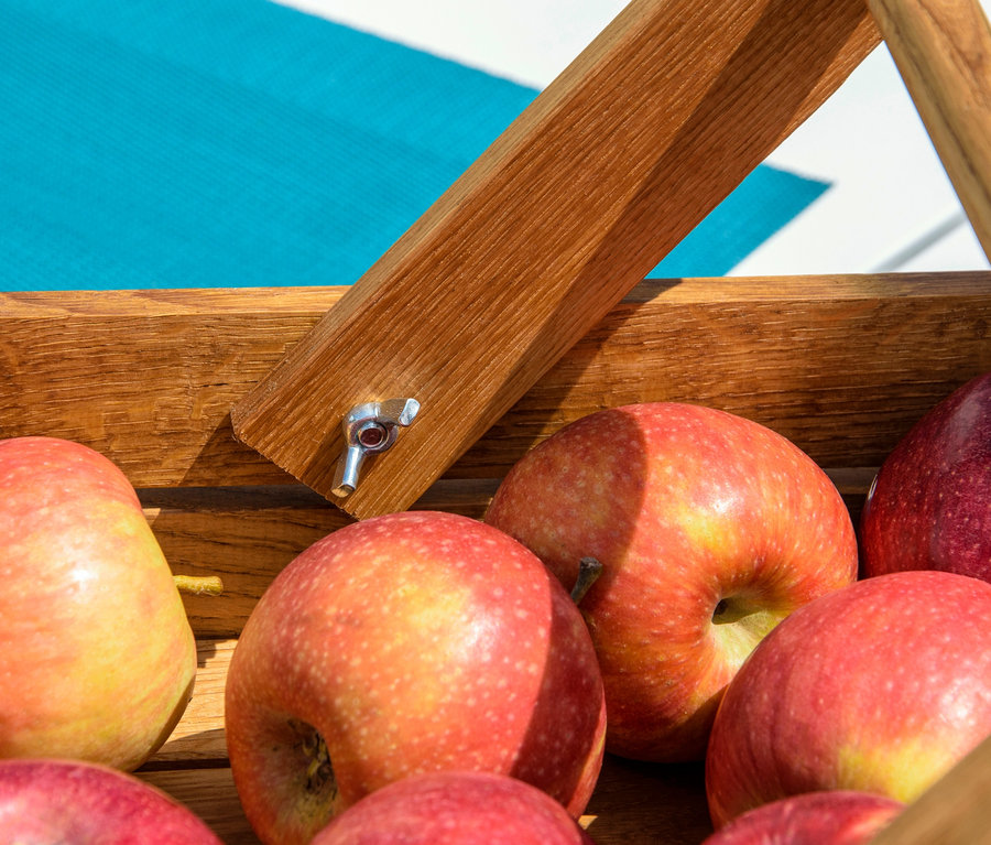 Rote Äpfel im Erntekorb aus Holz.