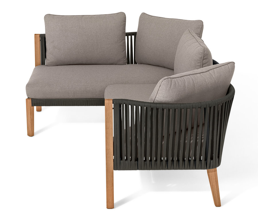 Lounge-Ecke mit Textilgeflecht und grauen Kissen.